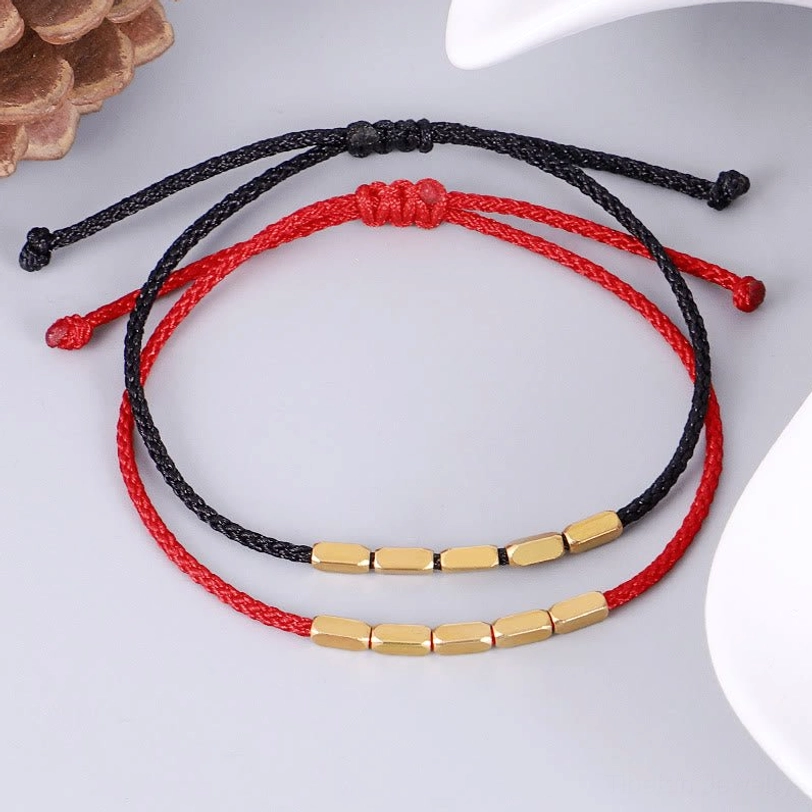 Pair of red and black Tibetan protection bracelets with matching copper beads displayed together