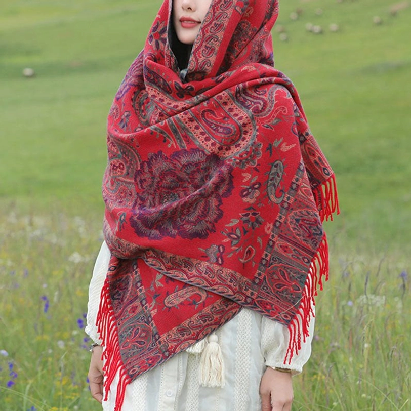Red bohemian tassel shawl detail view, thick fringe edge and intricate ethnic weaving in warm tones