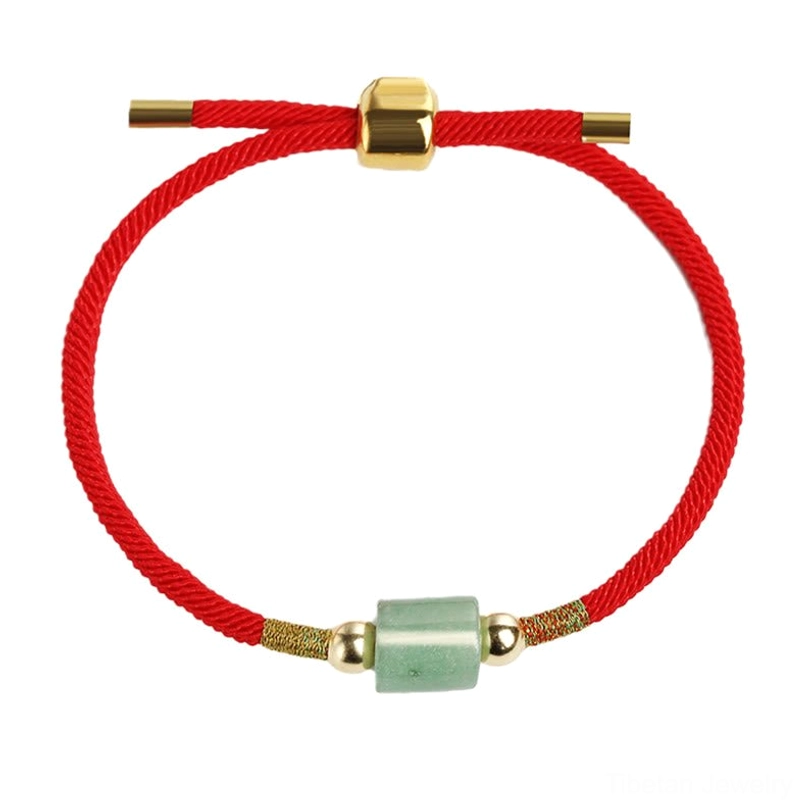 Full view of red Tibetan woven protection bracelet with light green barrel gem and gold metal accents on white background