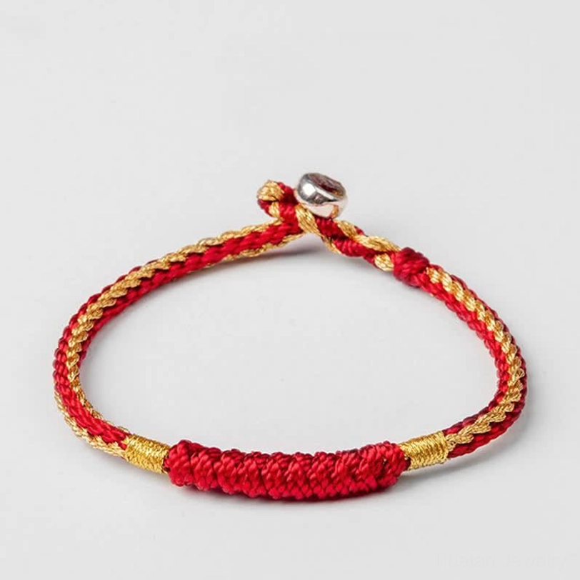Tibetan handmade red braided protection bracelet with thick woven central section and adjustable silver clasp
