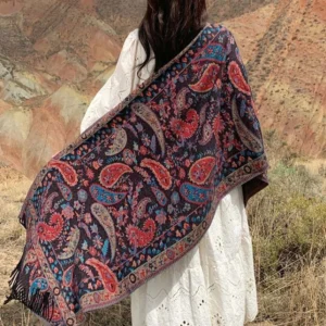 Tibetan paisley tassel shawl in red - back view outdoor mountain scene showing handwoven ethnic embroidered pattern