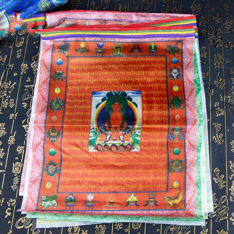 Stack of red Tibetan prayer flags with Buddha image and auspicious Buddhist patterns on printed calligraphy background