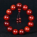 Tibetan red sandalwood mala bracelet with 108 beads, overhead view showing individual round wooden beads in warm reddish-brown tones