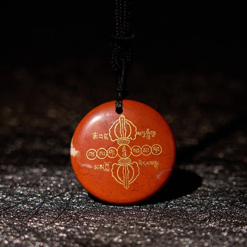 Red stone Vajra Dorje Tibetan necklace pendant with golden engraved patterns and black braided rope