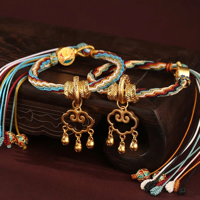 Handwoven tibetan reincarnation knot bracelet with cloud lock pendant, gold bell accent, and multicolor cord detail