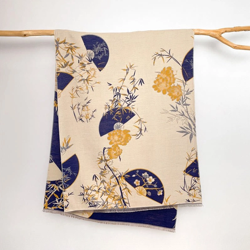 Handwoven Tibetan scarf with bamboo and peony flowers in cream and navy flat lay on wooden hanger
