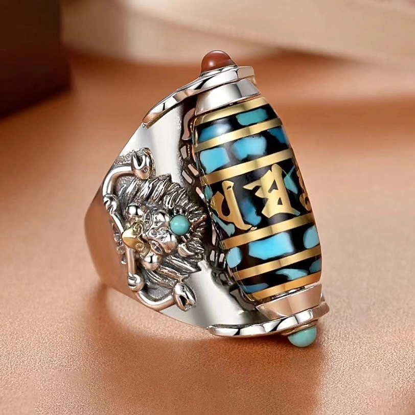 Tibetan spiritual ring side profile displaying silver Garuda ornament, blue enamel dzi bead, and decorative gem inlays detail