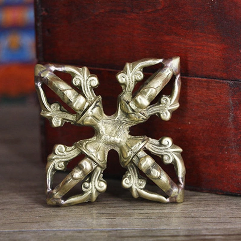Tibetan ritual dorje vajra displayed front-angle view with neat scrollwork prongs, uniform hollowed design, and aged bronze patina finish