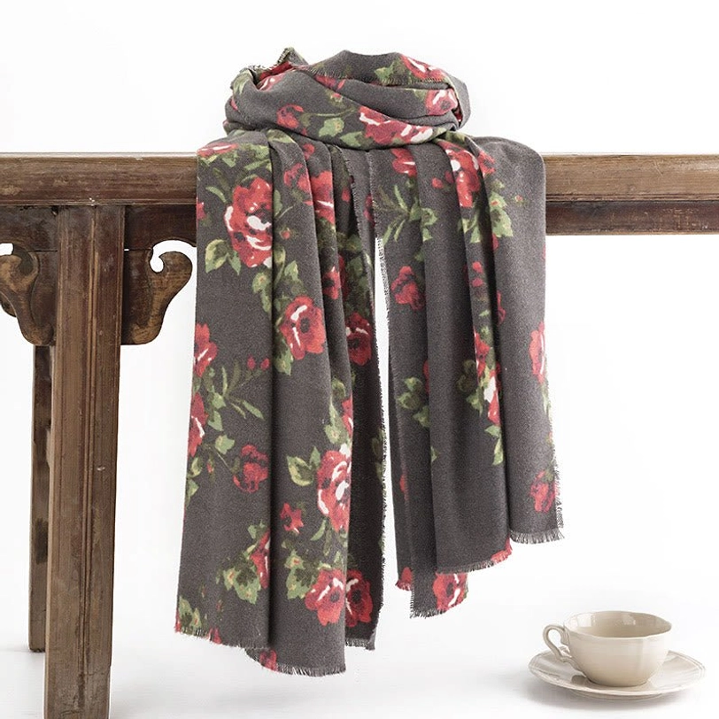 Tibetan rose floral shawl hanging on wooden rack with coffee set, showing natural drape and frayed hemline