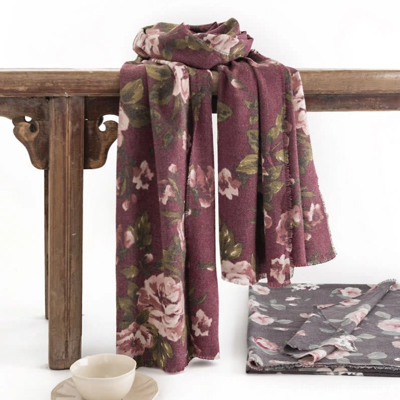 Two Tibetan rose shawls in burgundy and dim gray displayed on vintage wooden bench showing folded texture and color options