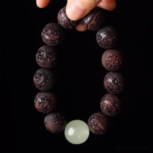 Tibetan rosewood Pixiu bracelet overhead view with intricate carved beads and jade spacer