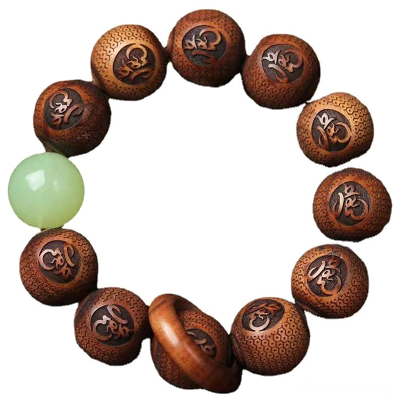 Full strand flat lay of Tibetan rosewood tiger protection bracelet showing complete circle of engraved beads with luminous green bead and dark wooden table background
