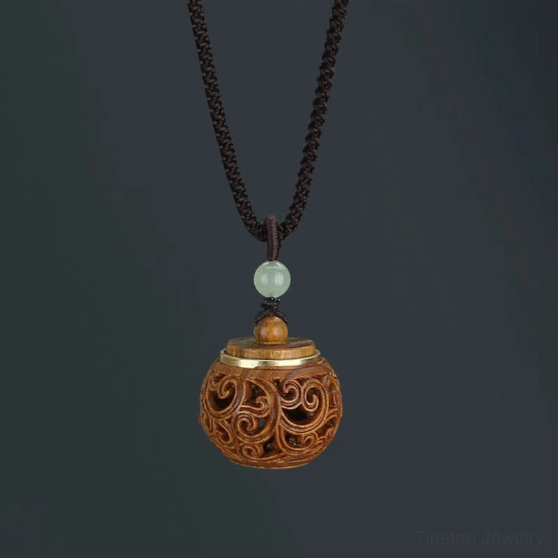 Round bottle-shaped green sandalwood Tibetan necklace pendant with symmetrical carving, overhead studio photography