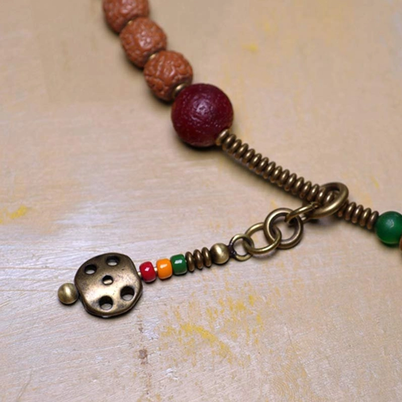 Authentic 108 Rudraksha Mala Bracelet with Nine-Eye Dzi Bead showcasing traditional Tibetan spiritual jewelry craftsmanship