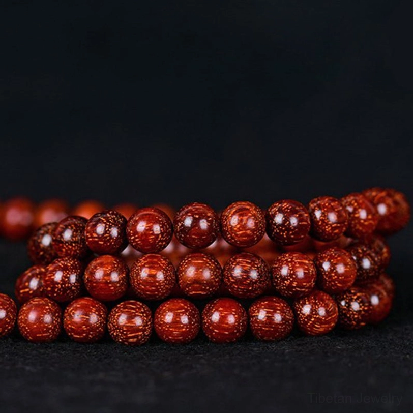 Multiple Tibetan red sandalwood mala bracelets in different sizes arranged together, showing size variety options