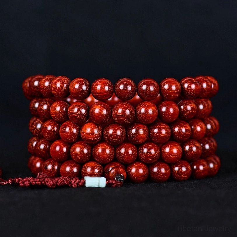 Tibetan red sandalwood mala beads close-up showing individual bead craftsmanship and natural wood polish