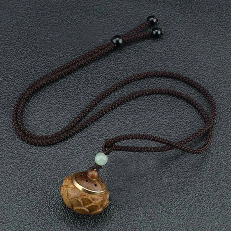 Tibetan green sandalwood necklace pendant collection showing multiple carving styles and natural wood variations