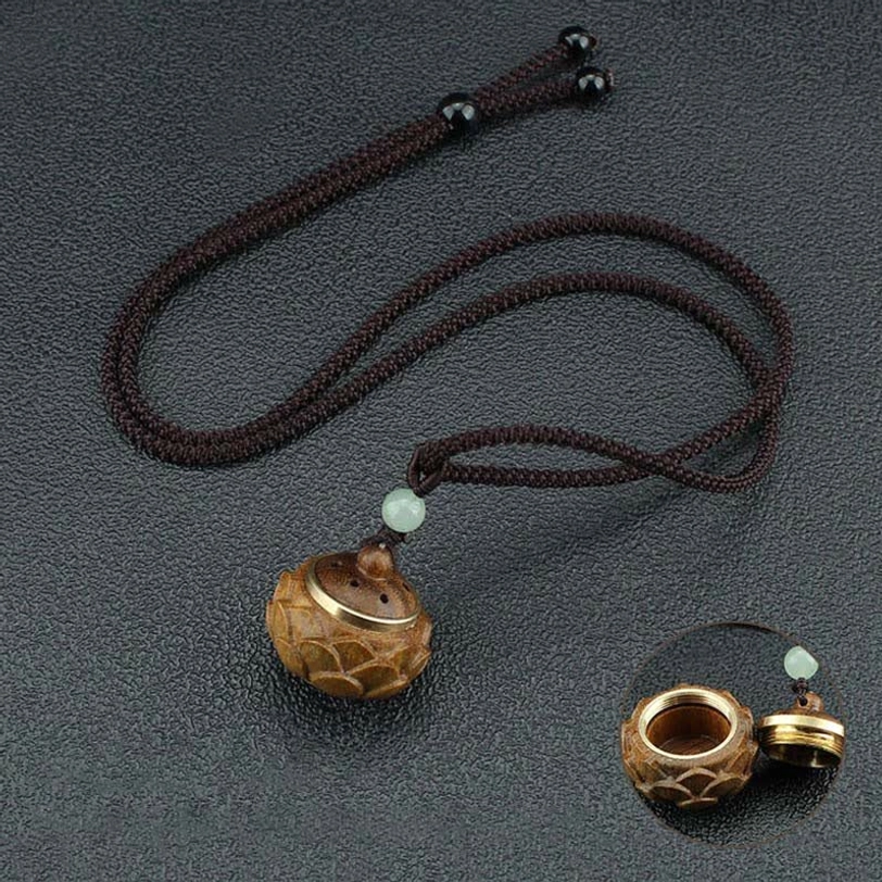 Green sandalwood Tibetan prayer pendant necklace with green aventurine and copper inlays, detail macro photography