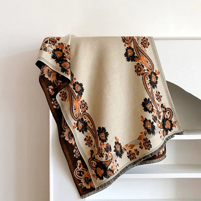 Beige Tibetan reversible scarf with traditional paisley floral patterns, flat lay shelf display highlighting soft fabric and fringe detail