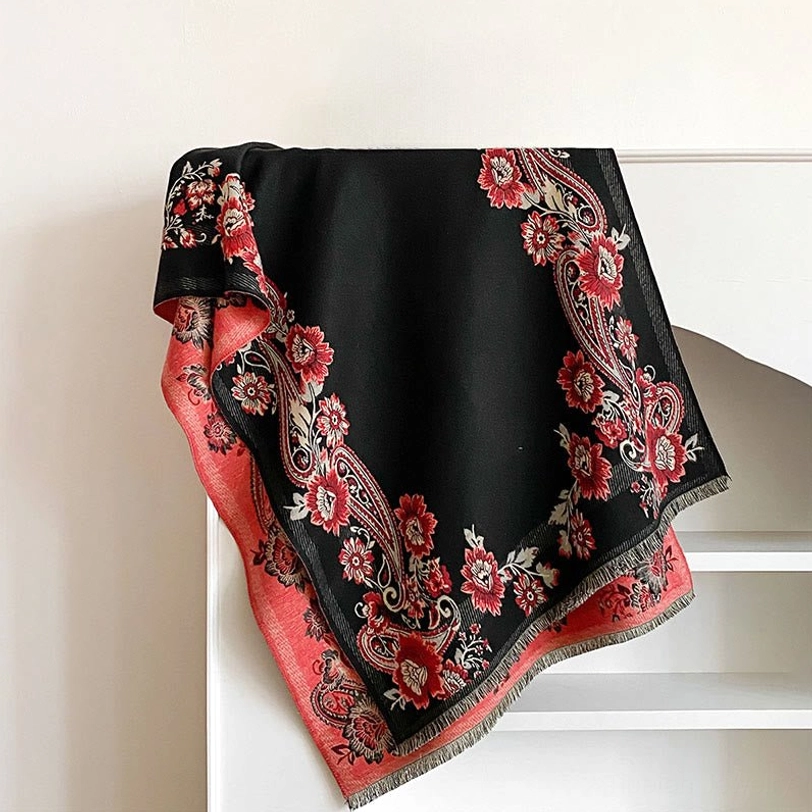 Black Tibetan reversible scarf with red paisley floral patterns and pink reverse side, flat lay display with fringe hem detail