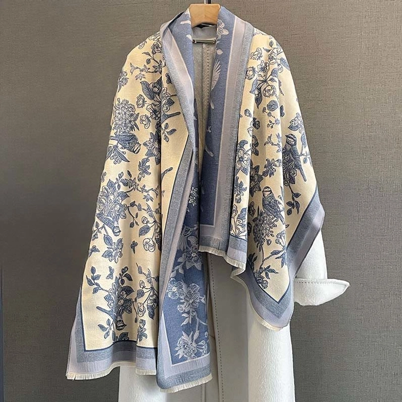 Blue trim Tibetan bird floral printed scarf draped over white coat front view cozy styling