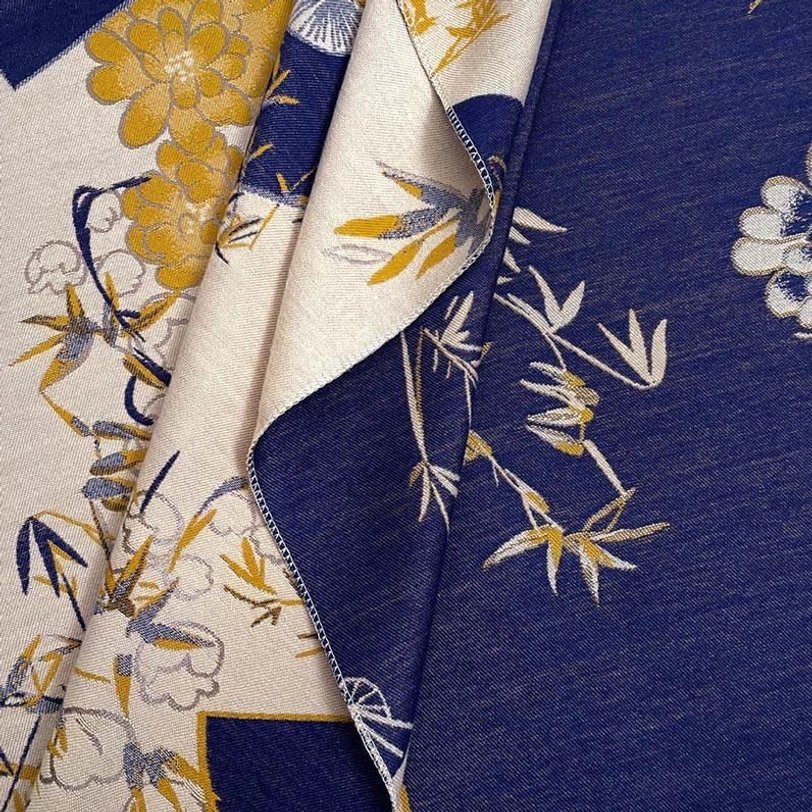Close-up overhead view of Tibetan handwoven scarf fabric showing bamboo peony pattern reversible weave detail