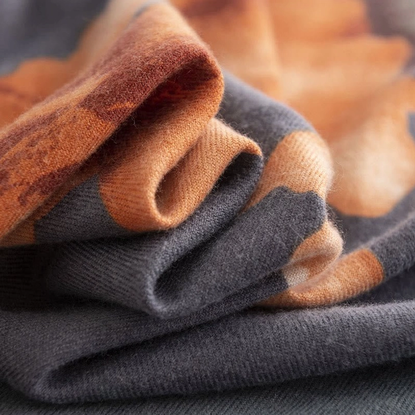 Close-up texture detail of Tibetan scarf showing soft brushed weave and orange-gray color blend