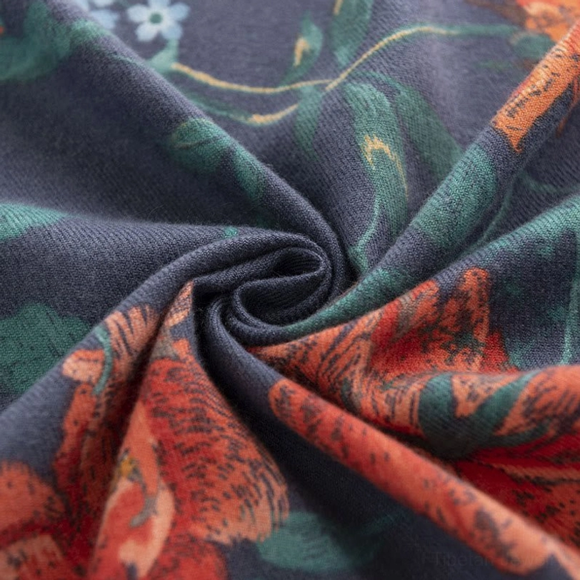 Close-up texture detail of Tibetan floral scarf fabric showing vibrant botanical prints and soft fuzzy knit weave with twisted fold