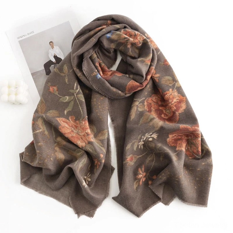 Rust-toned Tibetan floral wrap scarf looped in elegant drape styling shown three-quarter overhead view on fashion magazine backdrop