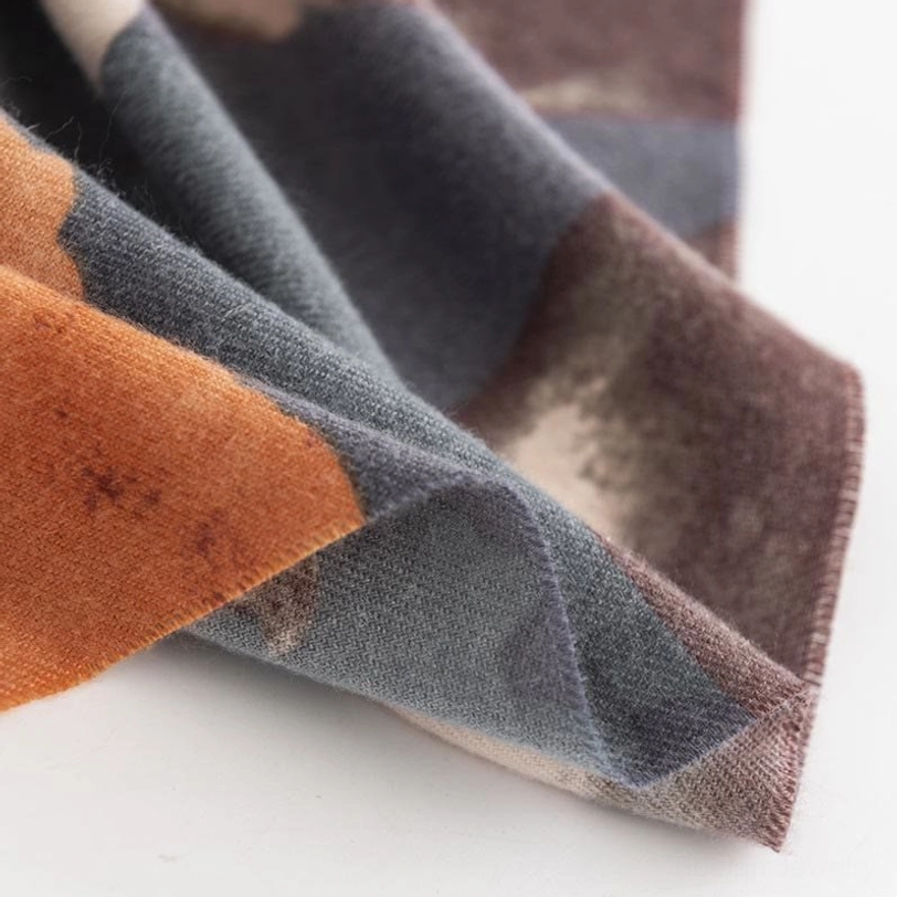 Folded edge detail of Tibetan hibiscus scarf showing mixed gray-orange prints and crisp construction