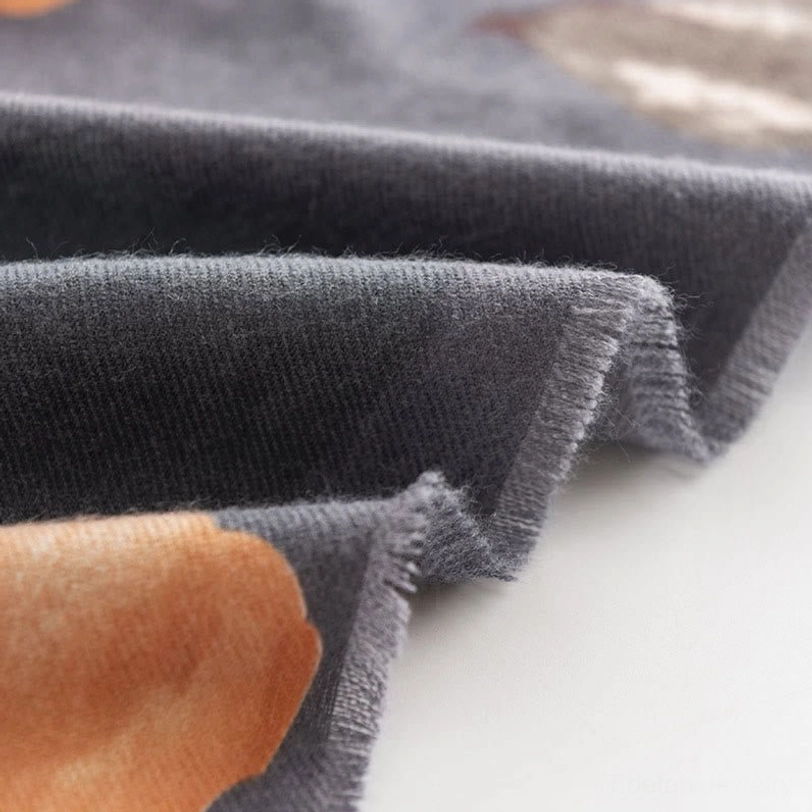 Tibetan scarf hem close-up showing frayed edges and soft dark gray matte texture