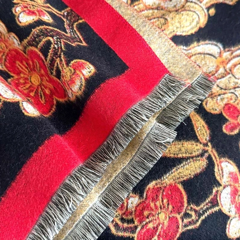 Tibetan scarf hem detail with double red fabric trim and grey frayed tassel edges showing handcrafted quality