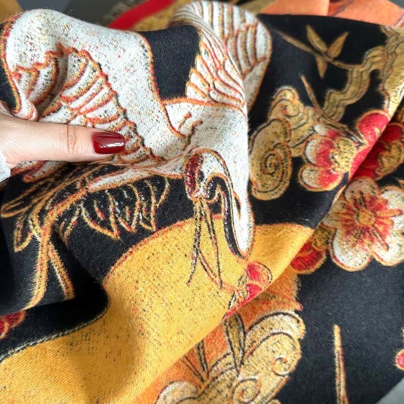 Close-up of woven jacquard texture showing crane birds, plum blossoms and auspicious cloud motifs