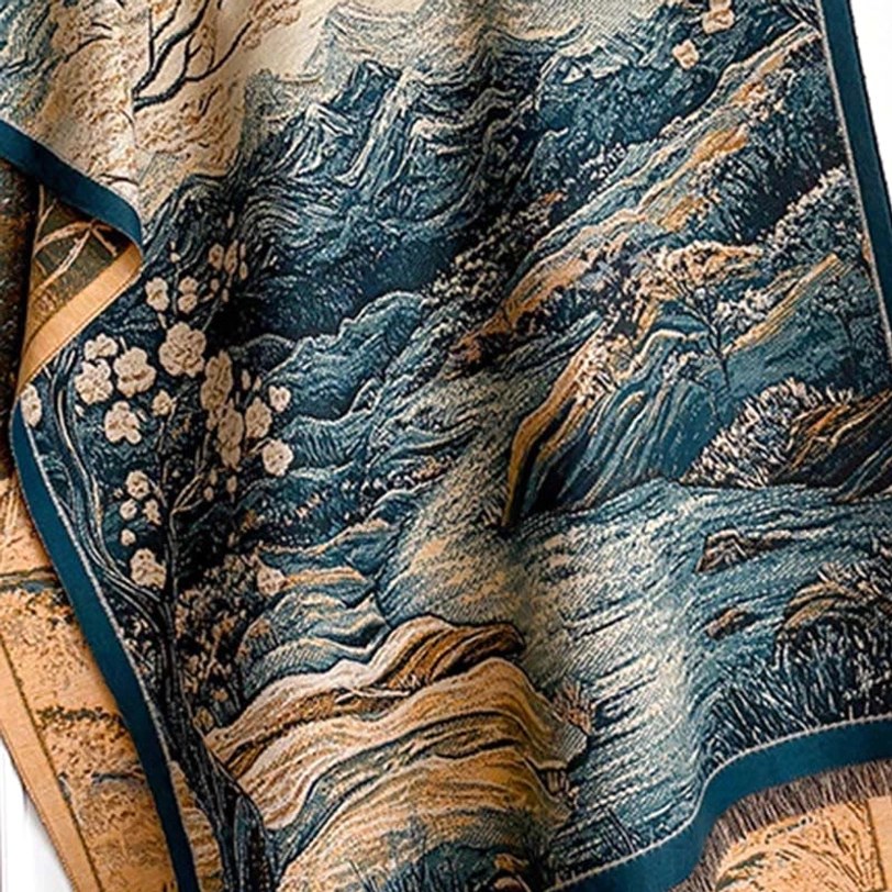 Close-up detail of Tibetan landscape scarf jacquard weave showing mountain and blossom pattern in teal, cream, and warm brown tones