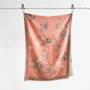 Dusty pink Tibetan scarf hanging flat with vintage border and bird flower motif against white backdrop