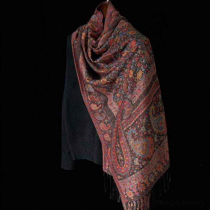 Tibetan jacquard shawl side view, showing border trim, all-over paisley motifs, and authentic tassel fringe
