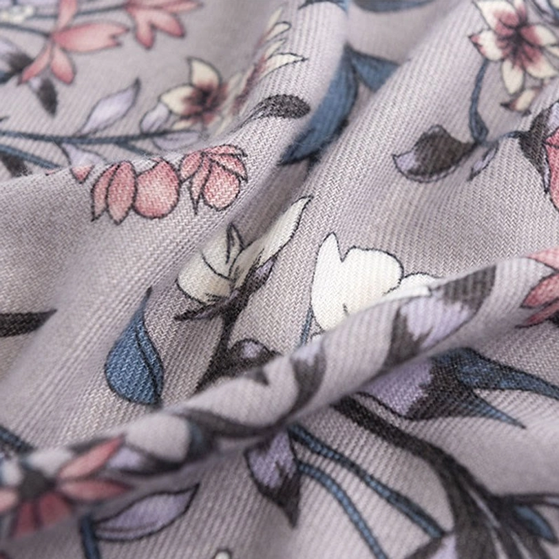 Tibetan floral scarf fabric close-up overhead, twill woven texture with mixed flower and leaf botanical design print