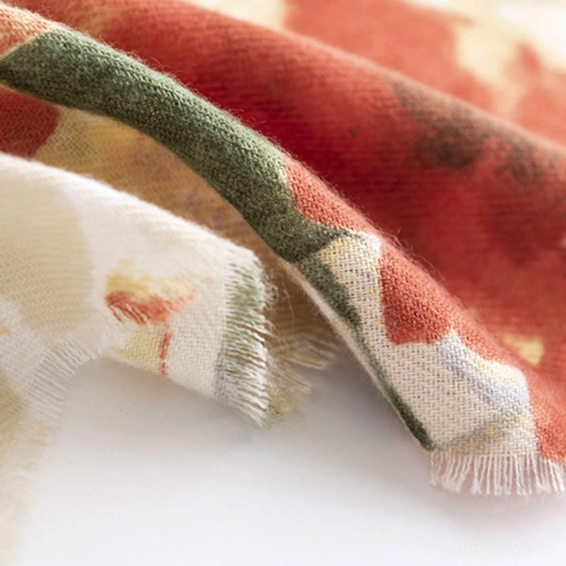 Tibetan floral fabric close-up with olive green rust and cream tones showing watercolor print and raw frayed hem edges