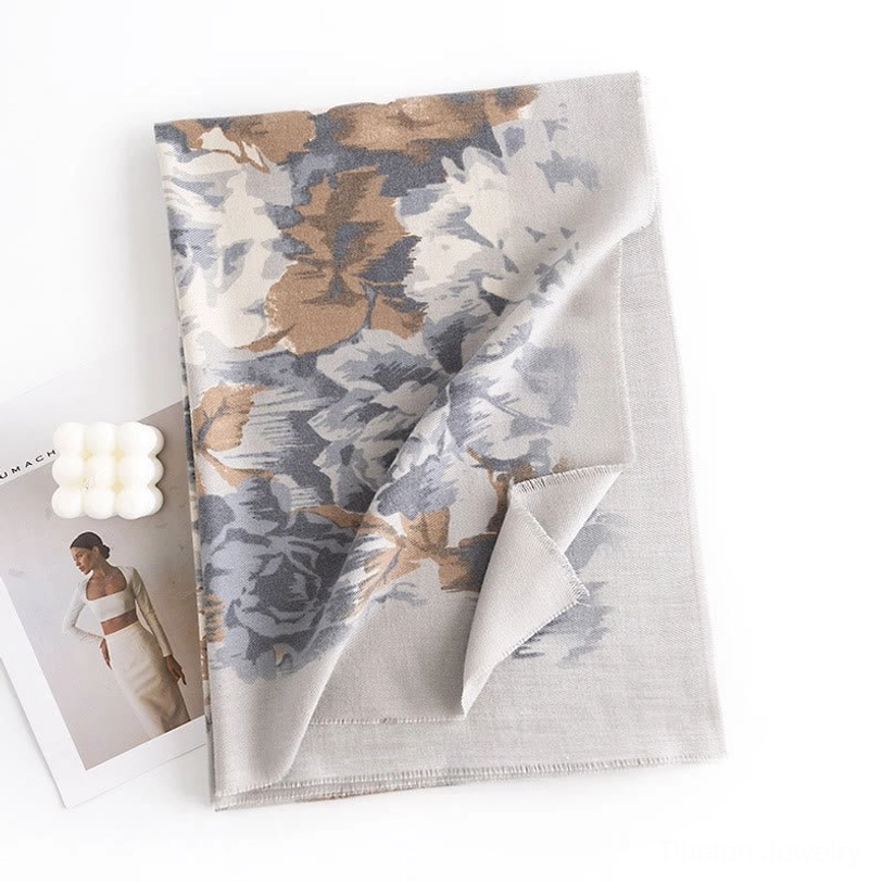 Wheat colored Tibetan scarf wrap displayed in flat lay with fashion magazine and candle prop, brown blue and grey neutral tone floral pattern