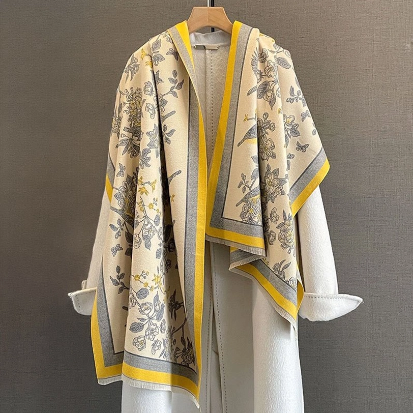 Yellow and grey trim Tibetan bird floral scarf draped over white coat styled front view