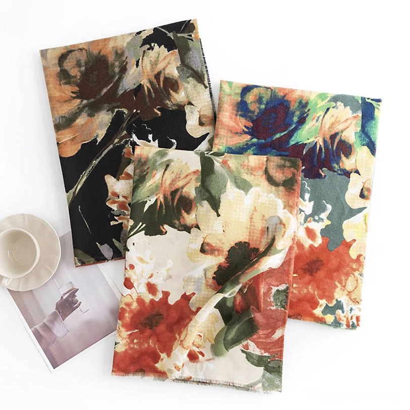 Overhead flat lay of three Tibetan ink scarves with assorted retro flower prints on cozy tabletop scene with coffee