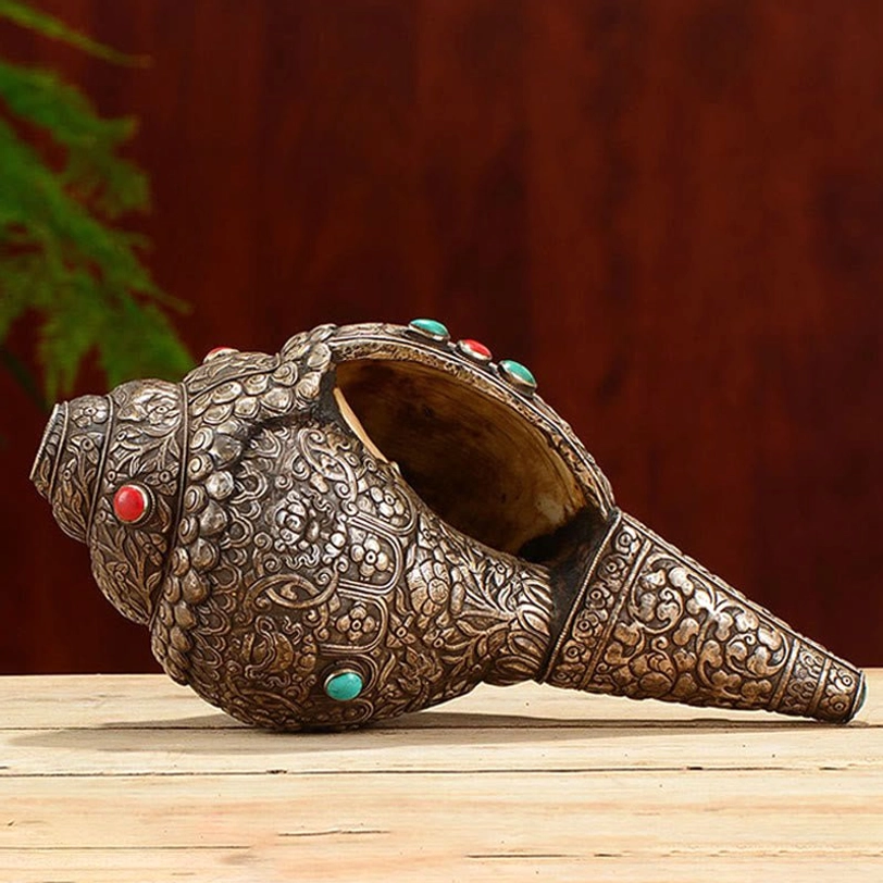 Open mouth cavity of Tibetan shankha conch shell showing hollow interior structure and silver carved details, horizontal side view