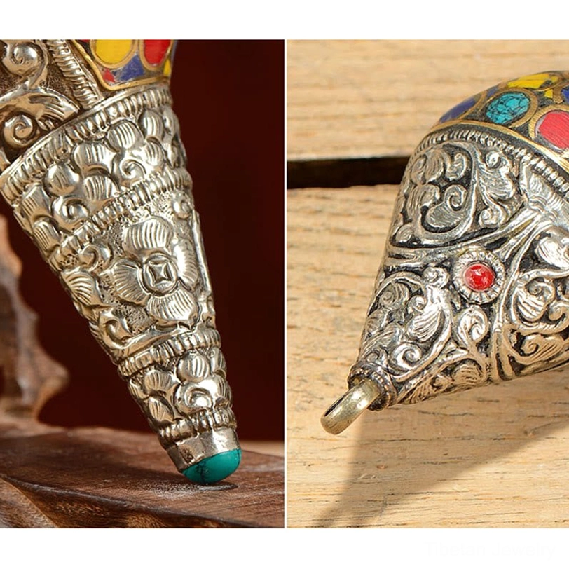 Close-up of Tibetan shankha conch shell metal tip with intricate silver floral embossing and turquoise gemstone