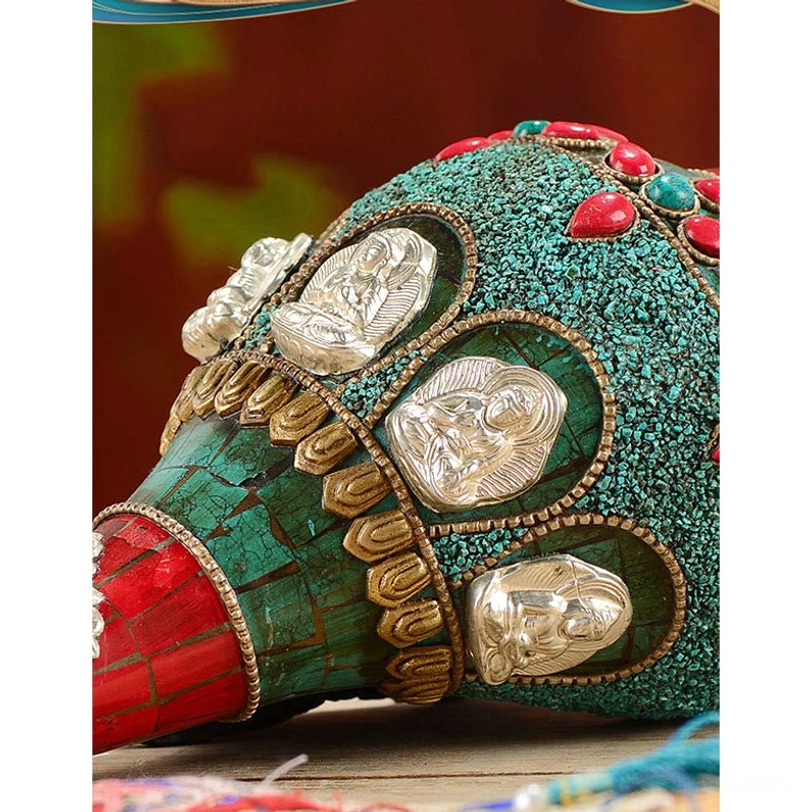 Ornamental Shankha conch detail showing silver Buddha figurines with turquoise and golden trim
