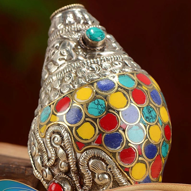 Front close-up of Tibetan shankha conch shell body showing dense colorful circular inlays and turquoise accent