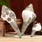 Tibetan shankha conch shell with carved silver dragon mounts and turquoise inlay on wooden display stand