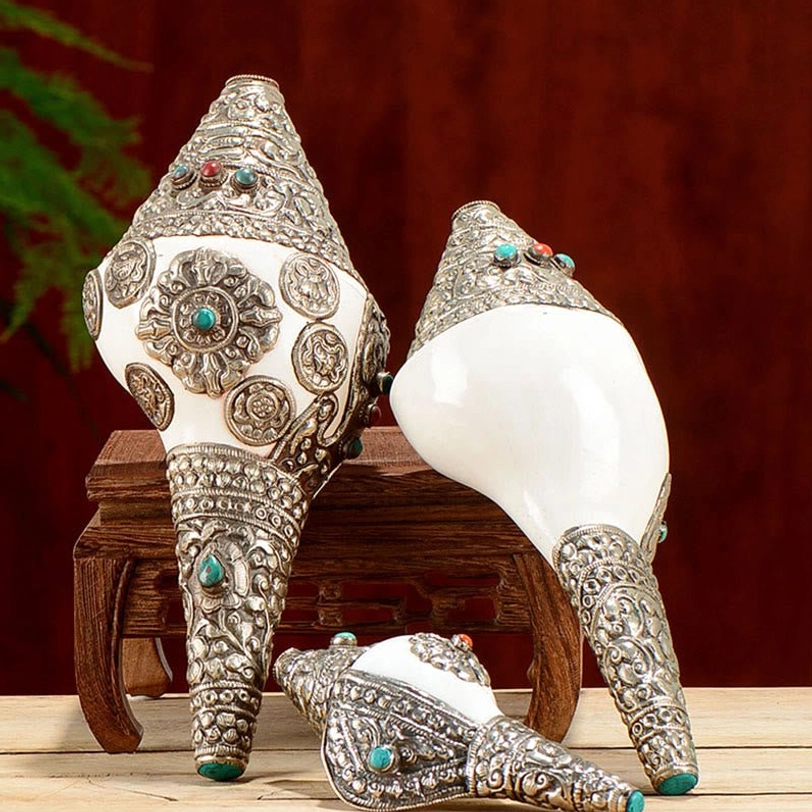 Top view of handcrafted Tibetan shankha conch shell showing intricate floral scroll silver carving and gemstone details