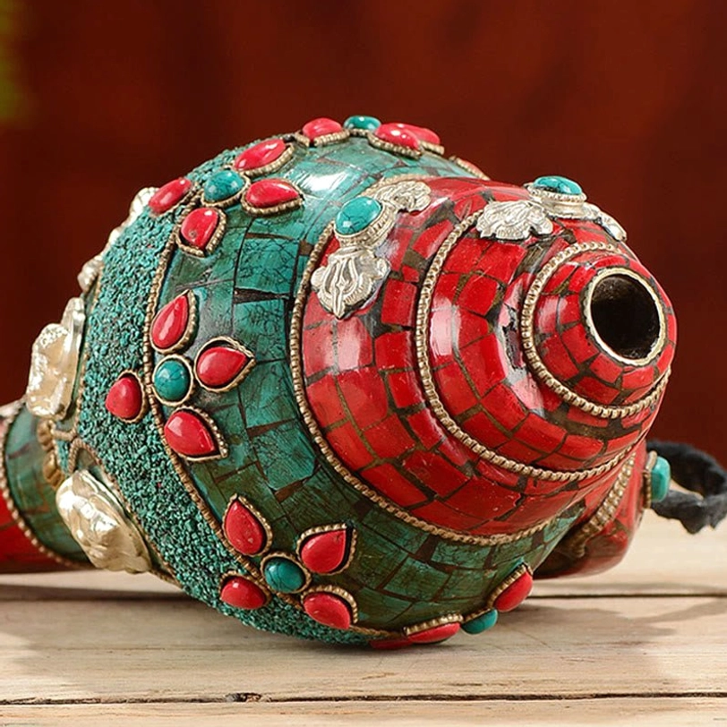 Close-up of Shankha conch spiral mouth with red turquoise inlay and decorative gemstones
