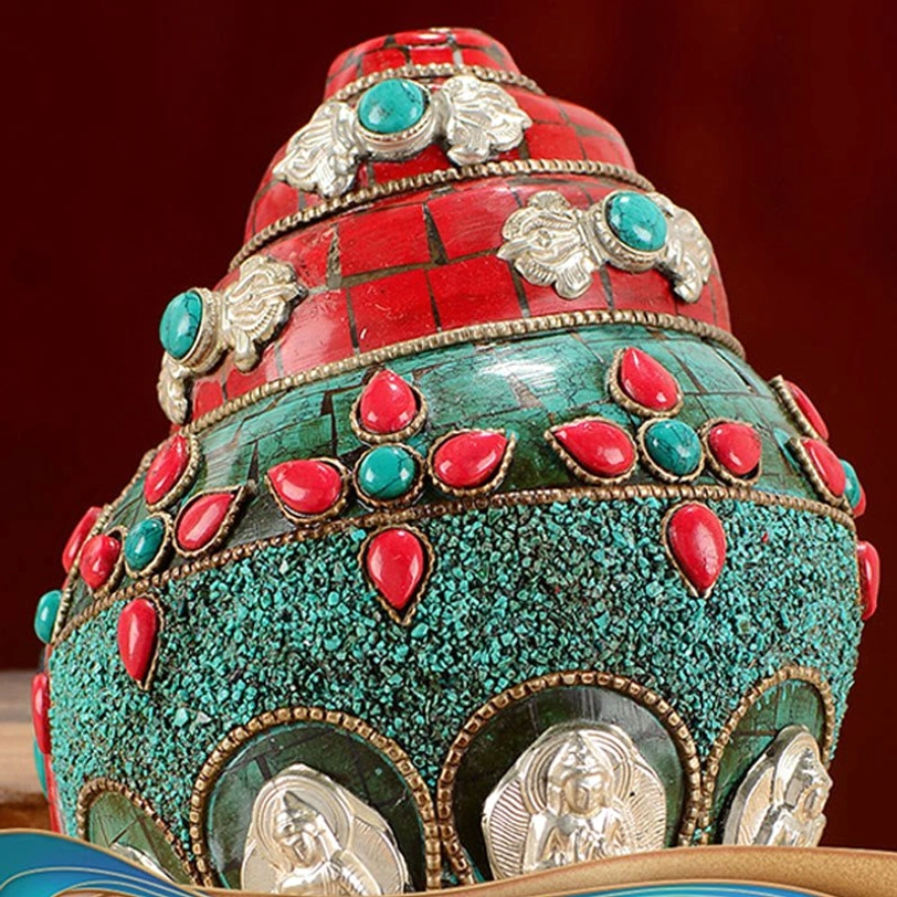 Front close-up of Tibetan Shankha conch decoration with crushed turquoise inlay and silver Buddha relief