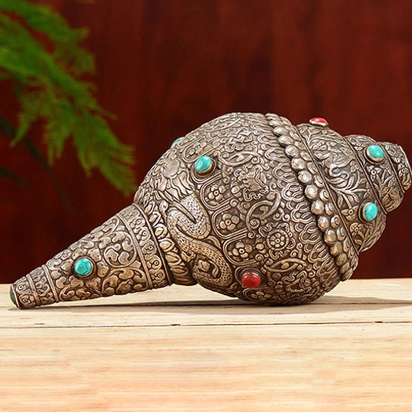 Tibetan hand-carved shankha with dragon and floral engravings, side oblique angle showcasing detailed auspicious symbol patterns and turquoise inlays